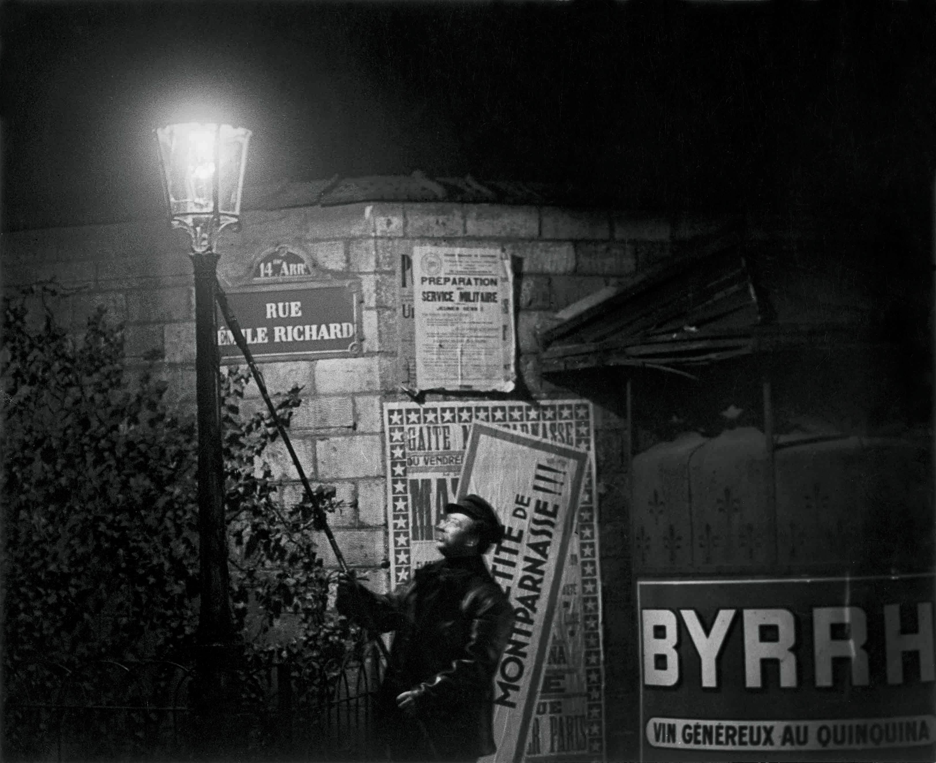 Brassaï. Extinguishing a Streetlight, rue Émile Richard. c. 1932 © Estate Brassaï Succession, Paris. 